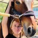 Brisa Galán equinoterapeuta, interactuando suavemente con un caballo